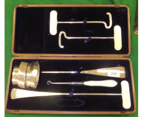 A fitted rectangular leather case containing boot pulls, slips and various other items by Pearl & Co. of Oxford Limited