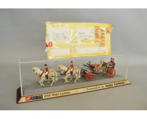 An unboxed  Corgi Toys '1902 State Landau' model, attached to plastic base mounted on a wooden plinth, the latter with an adh