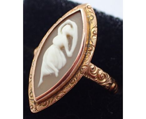 Ring set with a marquise shaped shell cameo in a rub over setting with an engraved border, plain patterned shoulders and a pl