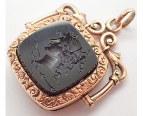 Swivel pendant set with a hardstone intaglio seal in an engraved border in a locket style mount with a scroll work top testin