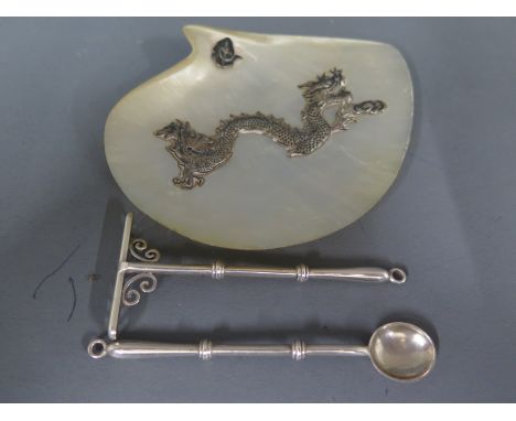 An Oriental mother of pearl dish decorated with a silver dragon on silver ball feet with an Oriental silver miniature rake an