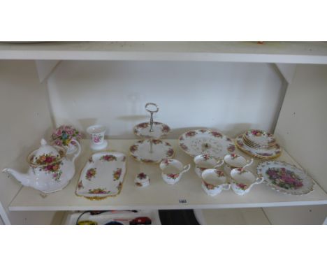 A Royal Albert Country Roses part tea service with five cups and saucers, cake plate, tea pot etc