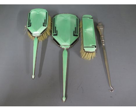 A silver hallmarked and enamel dressing set consisting of hand mirror brush, clothes brush and a silver hallmarked handled bu
