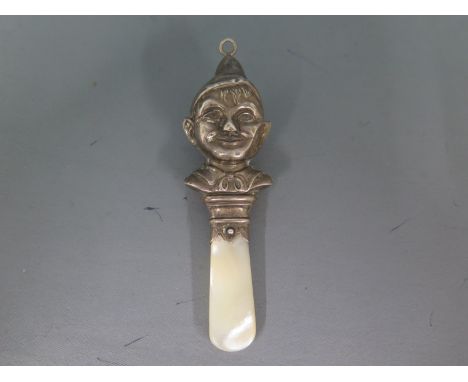 A baby's silver hallmarked rattle in the form of an elf's shoulders and head with mother of pearl teether mark for Chester 19