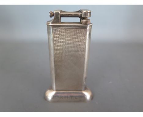 A vintage silver plated Dunhill lighter, engine turned finish to main body, R.H.Y.C. engraved to base - Height 10cm Condition