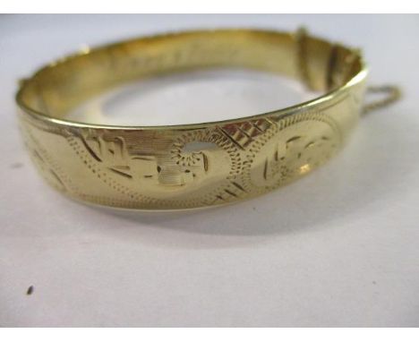 A 9ct gold and metal core bangle with safety chain 