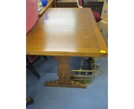 An oak extendable dining table, 29" x 45" x 28", along with a reproduction beige upholstered, wing back armchair on short cab