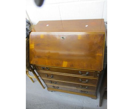 A modern yew four drawer bureau, raised on bracket feet 