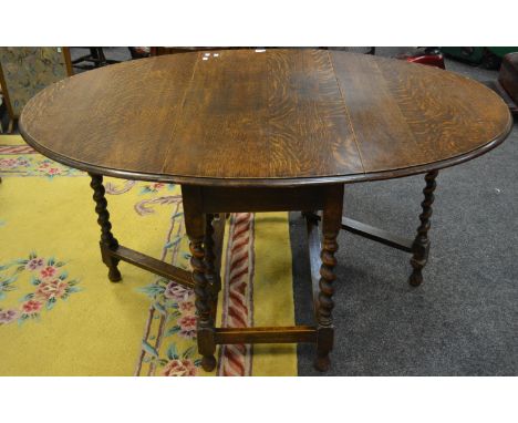  An early-20th Century oak gate leg table, barley twist supports