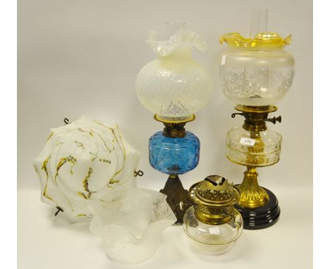 A Victorian glass oil lamp; another early 20th century blue glass reservoir; a marbled glass light shade;etc 