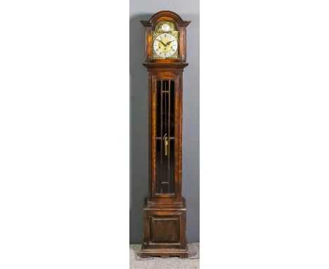 A 1920s oak "Grandmother" clock, the 11.5ins arched brass dial with silvered chapter ring with Roman and Arabic numerals and 