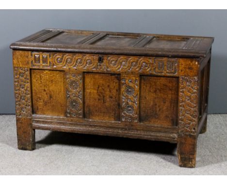 A 17th Century panelled oak coffer with three panel lid and front, the front carved with entwined circular motifs, 45.5ins wi