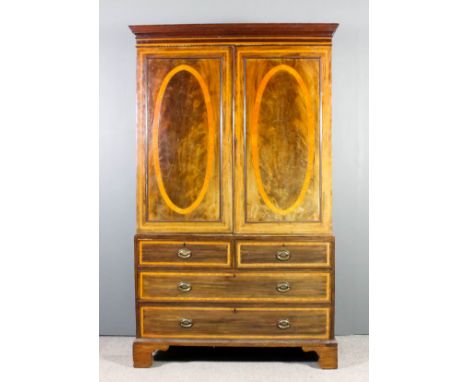 A late Georgian gentleman's mahogany wardrobe, the front later banded in satinwood, the upper part with moulded cornice and f
