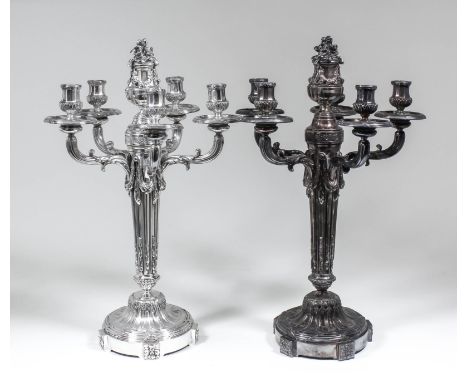 A pair of George V silver five light candelabra of Louis XVI design, the centre column surmounted by a moulded urn, bold flor