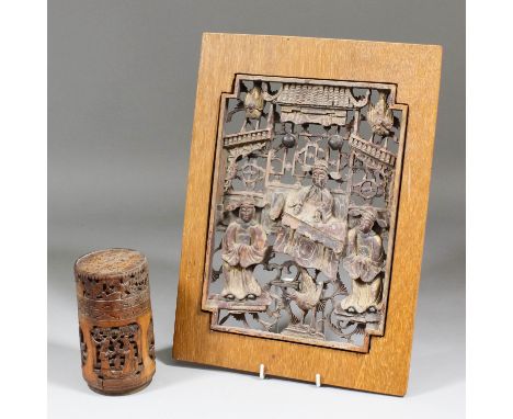 An early 20th Century Chinese carved and pierced wood panel with figures and birds in a pavilioned landscape, with traces of 