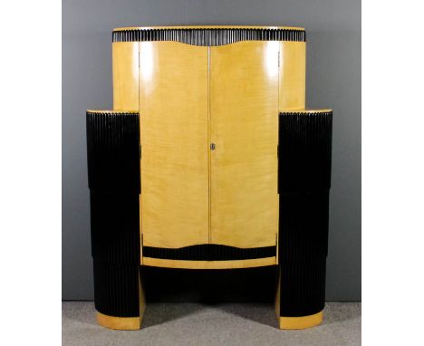 A 1930s Continental satin birch and ebonised oval cocktail cabinet of Art Deco design with reeded mouldings and bowed ends, f