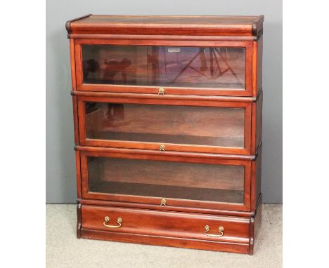 An early 20th Century Globe Wernicke mahogany three tier sectional bookcase, each tier enclosed by rising glazed panel and fi