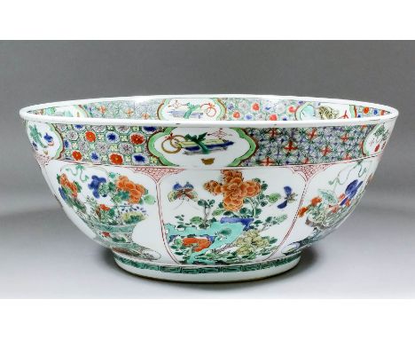 A Chinese porcelain bowl enamelled in the "Famille Verte" manner with eight panels depicting vases and open baskets of flower