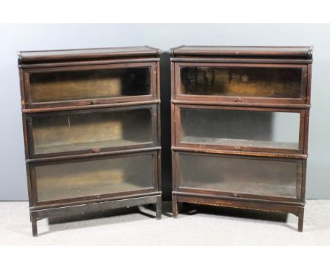 A pair of Globe Wernicke oak three tier sectional bookcases, each tier enclosed by a rising glazed panel, on square legs, 34i