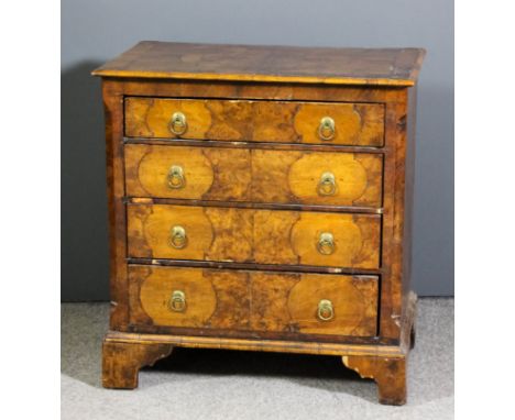 A walnut chest of 18th Century design, the top crossbanded and inlaid with stringings, with moulded edge, fitted four long dr