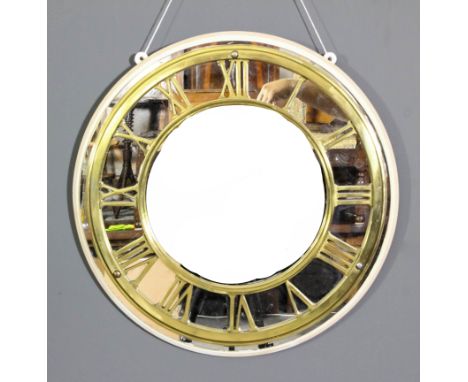 A heavy brass circular clock chapter ring, with Roman numerals, 18ins diameter, mounted on circular mirror panel and painted 