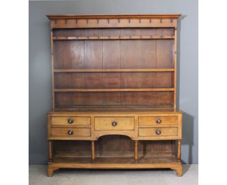 An early 19th Century oak dresser, the upper part with moulded cornice, fitted three open shelves, the frieze and upper shelf