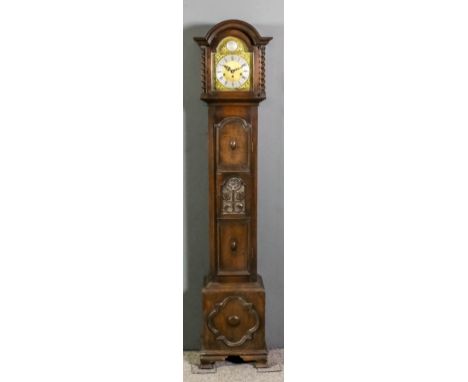 A 1920s dark oak "Grandmother" clock, the 8ins arched brass dial with silvered chapter ring with Roman and Arabic numerals an