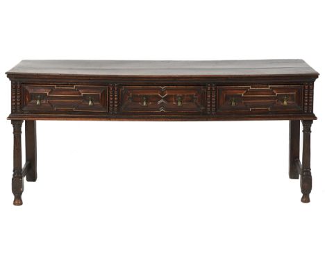An oak dresser, the moulded top fitted three geometric moulded drawers between split bobbin mouldings, brass axe head handles