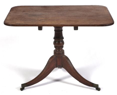 A Regency mahogany breakfast table, early 19th c, with tip-up crossbanded oblong top and turned pillar, on reeded tripod with