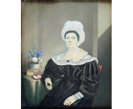 British Naïve Artist, mid 19th century - Portrait of a Lady, seated three quarter length in a black dress holding a miniature