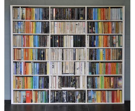 Smith (Philip, 1928-). Book-Face, book-wall installation composed of approximately 700 paperback books on a white shelf unit 