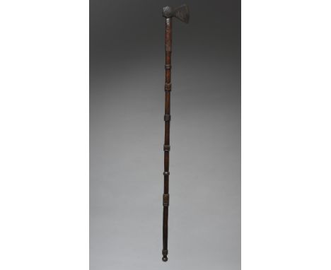 A North American axe with a long carved and knopped shaft and a European iron axe head stamped WYNN, 120.5cm long.