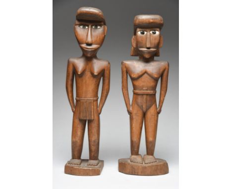 A pair of Micronesia standing figures probably Caroline Islands male and female with inset mother of pearl and applied gum ey