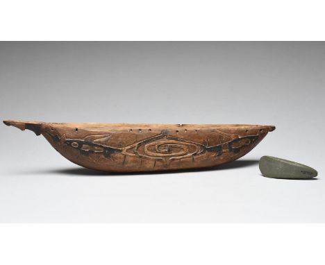 A Humboldt Bay model canoe Irian Jay, Indonesia with carved fish and black stain decoration, 45.5cm long, and a Solomon Islan