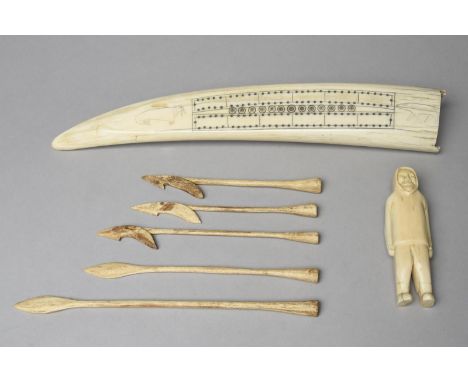 λAn Inuit cribbage board Arctic walrus ivory, carved a walrus and polar bear, 32.5cm long, an Inuit carved walrus ivory figur