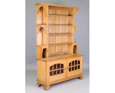 An early 20th century Arts and Crafts oak dresser, in the manner of Liberty &amp; Co, the shelf back with Moorish arches, the