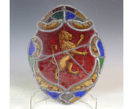 A 19th century stained and leaded glass shaped oval panel, decorated with a lion rampant within an acanthus leaf border, heig