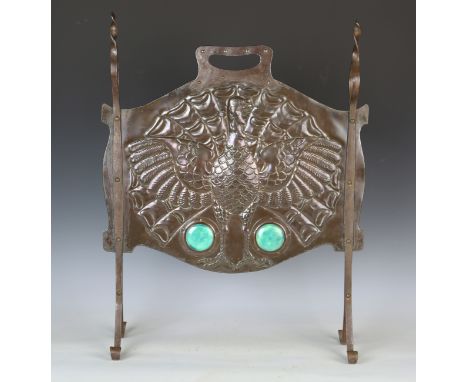 An Arts and Crafts patinated copper and steel mounted firescreen, the shaped panel inset with two large green glazed Ruskin p