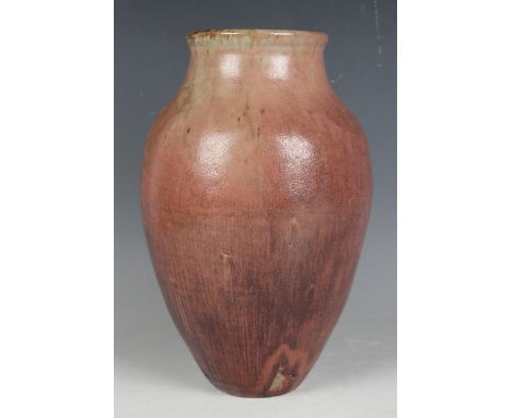 A Reginald Wells Coldrum Pottery vase, circa 1910-24, the tapered ovoid body covered in a streaked and shaped pink to red gla