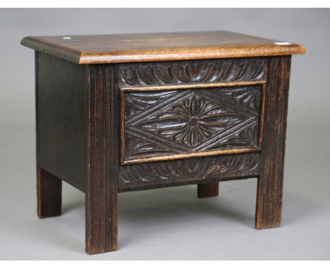 A late 19th/early 20th century oak coffer, the hinged lid above a carved panel front, height 48cm, width 61cm, depth 39cm.Buy