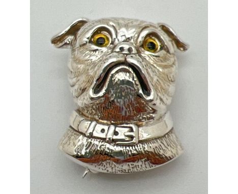 A sterling silver brooch/pendant in the shape of a dogs head with yellow glass eyes. Reverse with pin fastening and pendant b