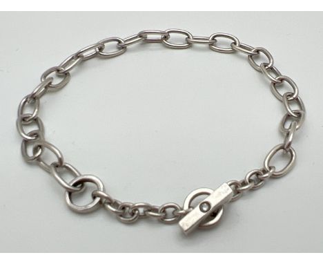 A modern design belcher chain style bracelet with T bar clasp. T Bar set with a small round cut diamond. Silver mark to bar. 