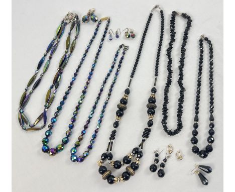 A collection of vintage black bead jewellery. To include iridescent finish bead necklaces with matching earrings, and a black