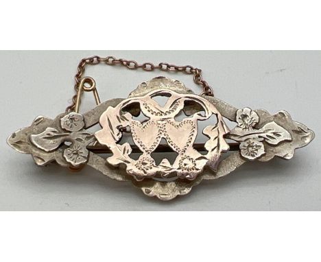 An antique silver and gold sweetheart brooch with pierced work detail and floral &amp; love heart decoration. Complete with s