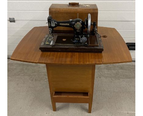 An early 20th century Jones CWS Federation Family hand sewing machine in a vintage sewing machine table. Shuttle bobbin machi