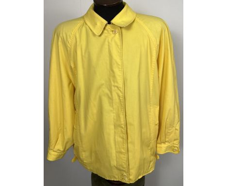 A ladies Burberrys yellow lightweight jacket. Front zip fastening with button cuffs and side adjusting buckles. Plus size 18.
