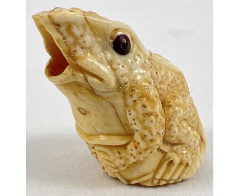 A carved bone? netsuke in the from of a frog sitting on a lily pad, with open mouth. Approx. 5cm tall. 