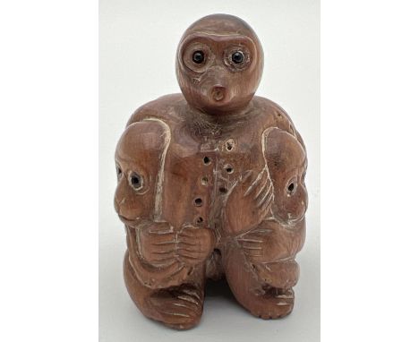 A carved wooden netsuke of monkeys and an octopus. Toggle holes to underside. Approx. 4.5cm tall. 