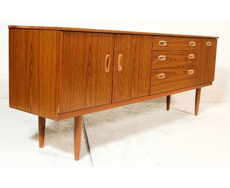 A vintage 20th century retro teakwood sideboard having a bank of three graduated drawers flanked by a twin door cupboard to t