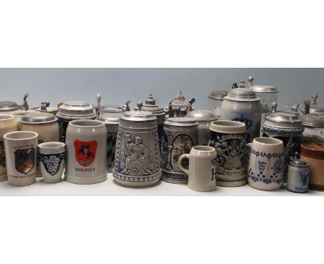 A collection of 20th Century German ceramic stein drinking glasses, each having raised decoration to the sides , many with na